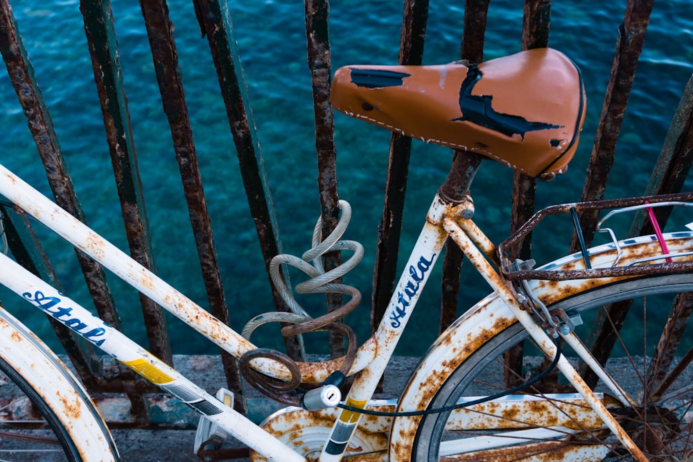 Vélo de ville blanc près d’un plan d’eau pendant la journée