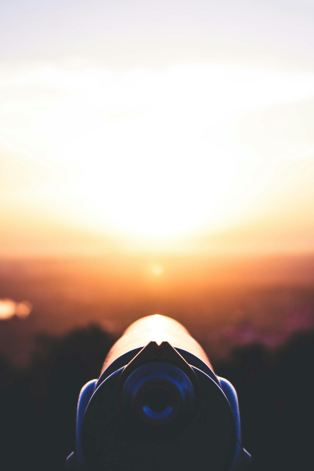 Nahaufnahme eines Teleskops mit der Sonne im Hintergrund