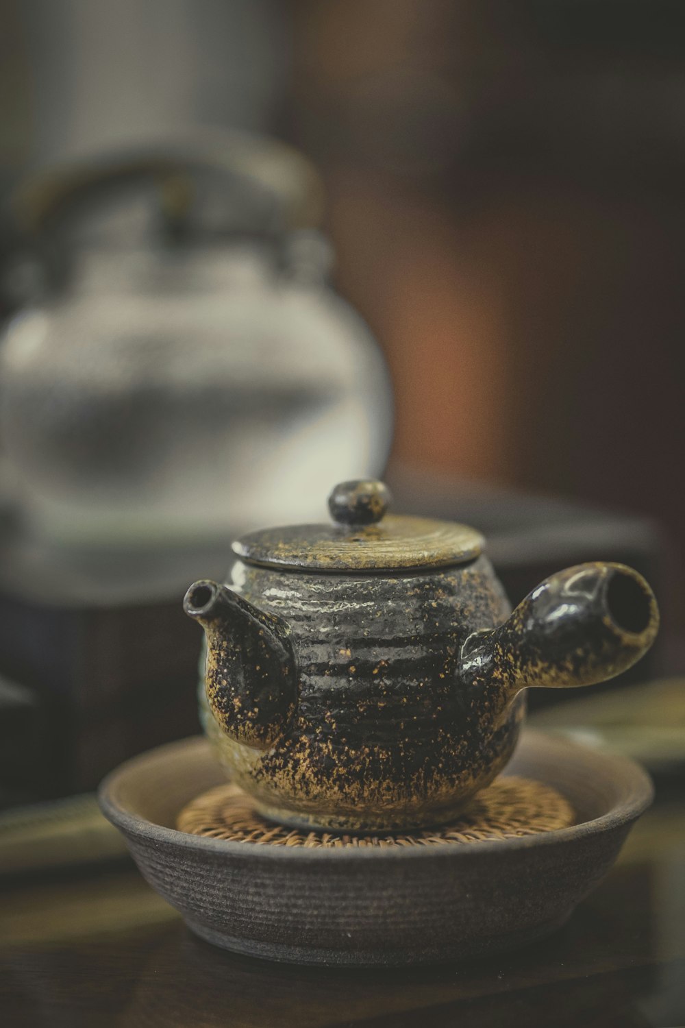 close-up photography of black ceramic pot on brown surface