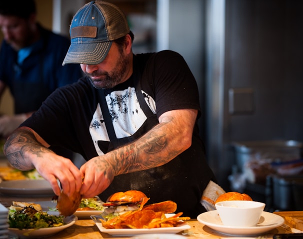 man standing beside table while holding food