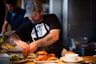 man standing beside table while holding food