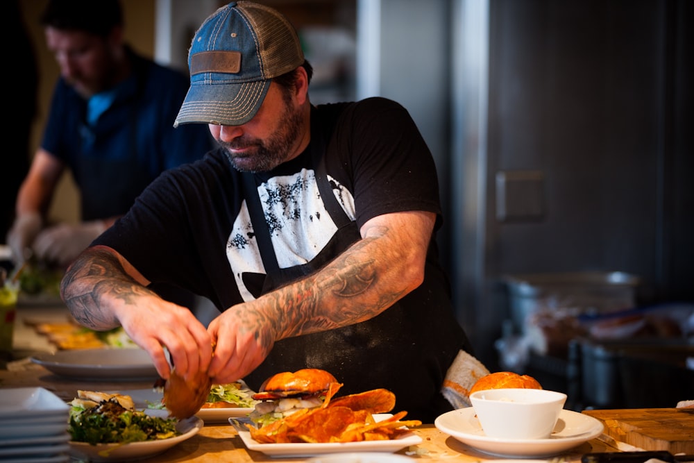 man standing beside table while holding food