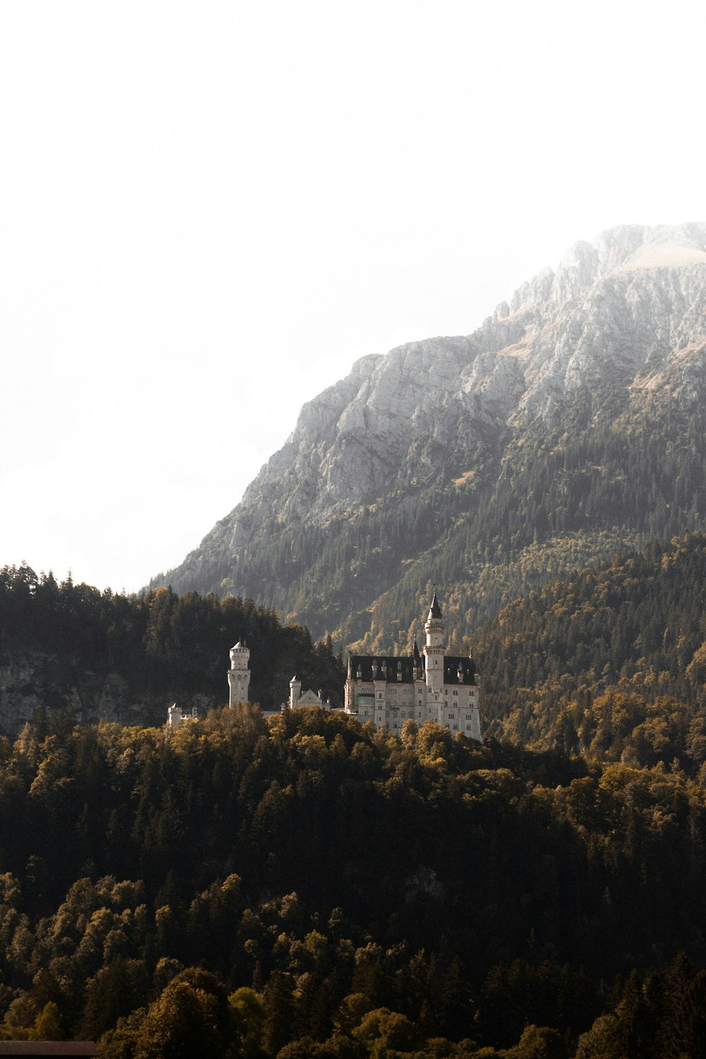 Edificio de hormigón blanco y marrón junto a la montaña durante el día