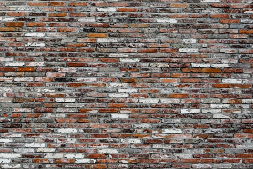 muro di mattoni marroni, bianchi e grigi