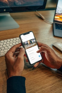 person holding iPhone on table