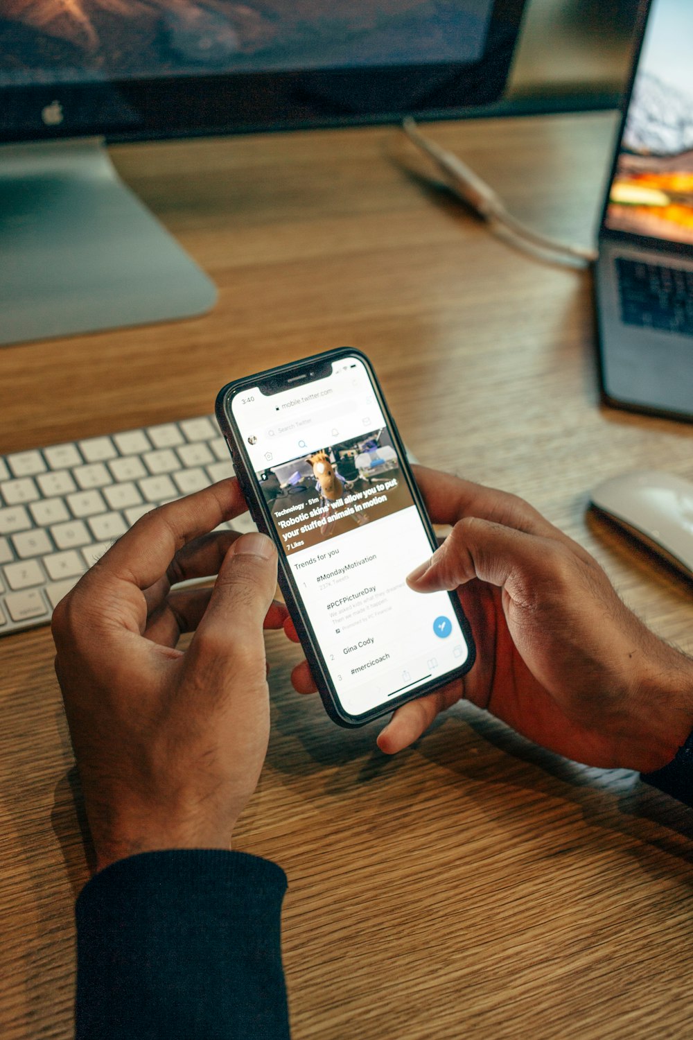 Person mit iPhone auf dem Tisch