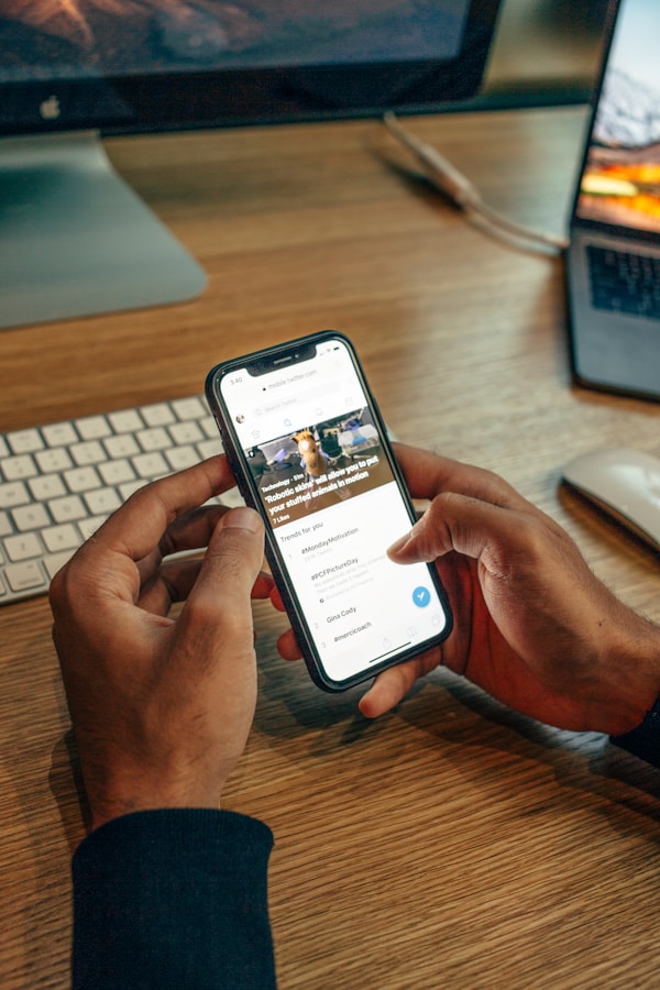 Persona sosteniendo un teléfono celular sobre una mesa