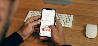 man holding phone while leaning on table