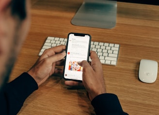 man holding phone while leaning on table