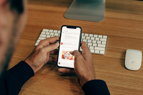 man holding phone while leaning on table