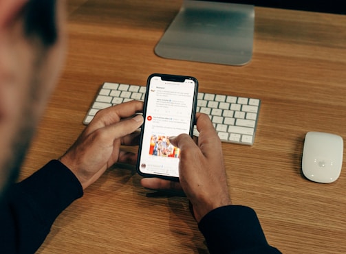 man holding phone while leaning on table