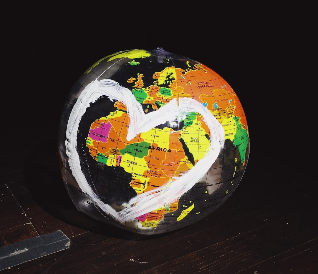 orange, green, and yellow globe on brown wooden surface