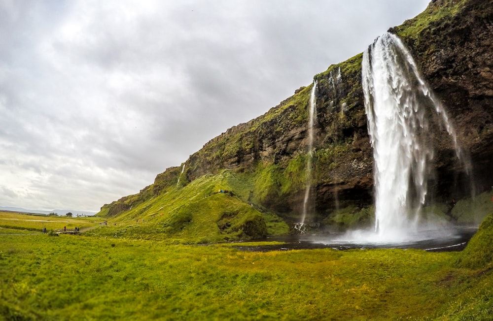 waterfall under cloudy sky