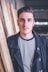 man standing beside wood planks