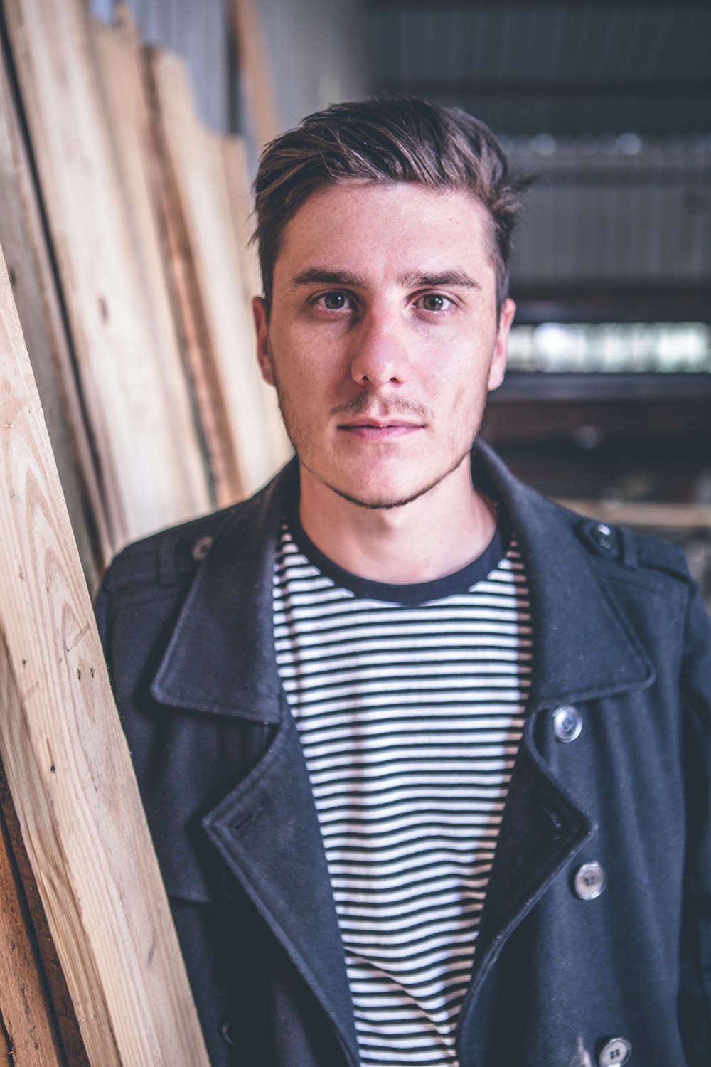 man standing beside wood planks