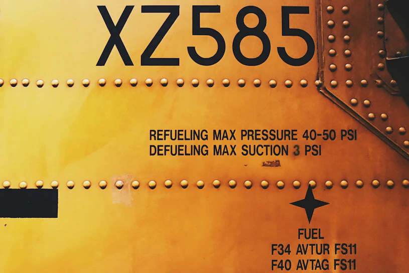 Close-up of a durable, custom-branded aircraft tag securely attached to an engine part, showing clear part numbers and maintenance data.