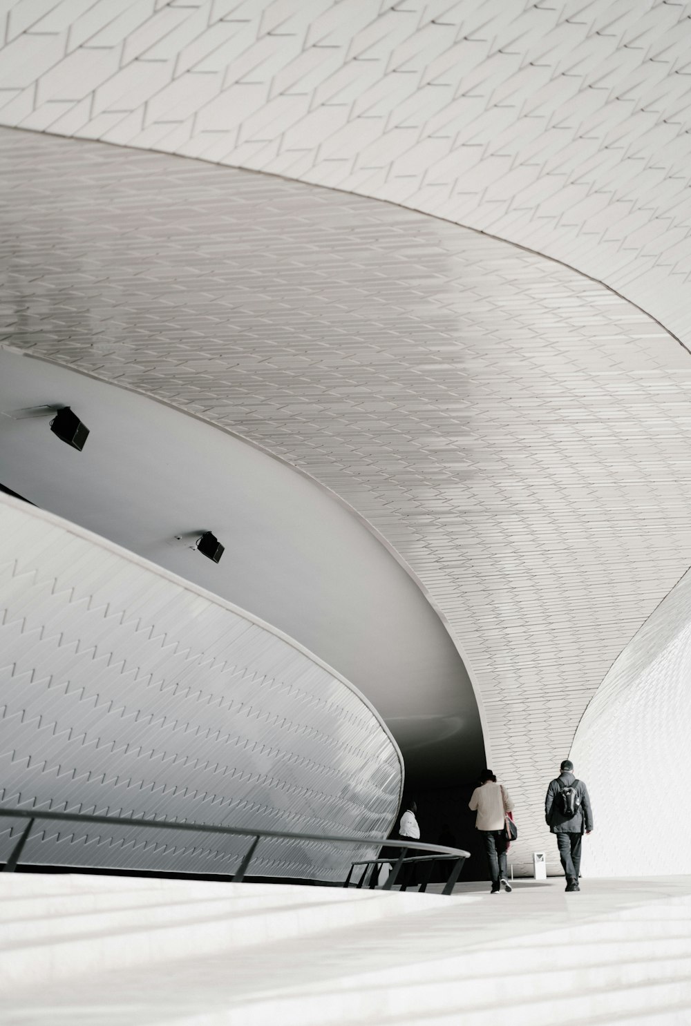 two person walking under white building