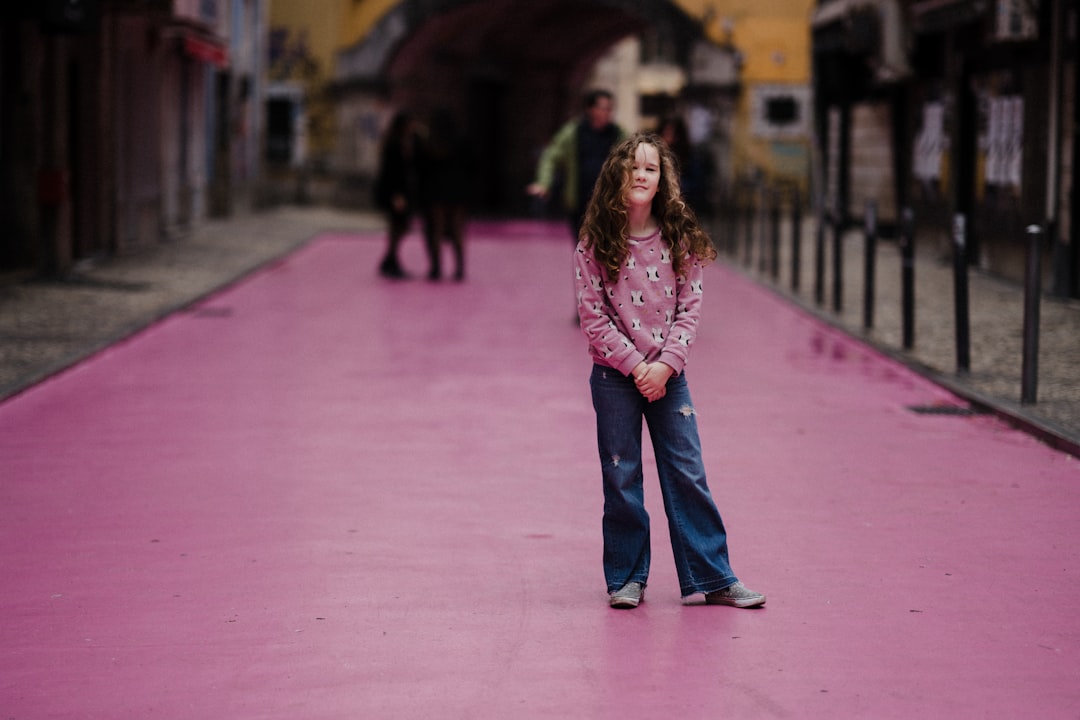 selective focus photography of girl on purple street