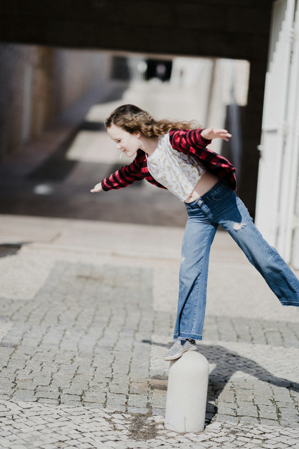 girl balancing on top of concrete stand