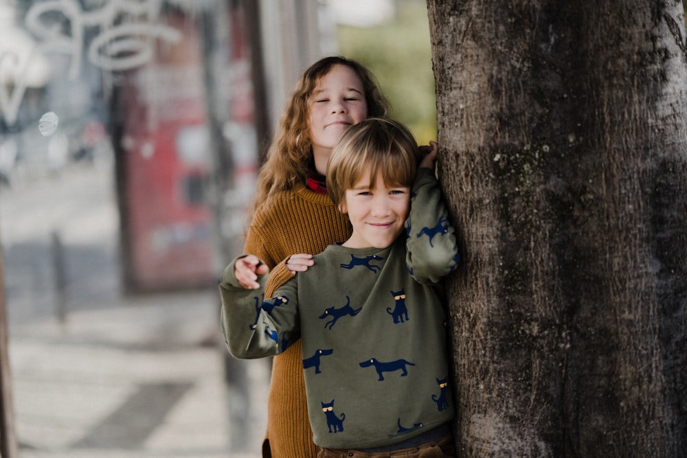 two young children hugging each other on a sidewalk