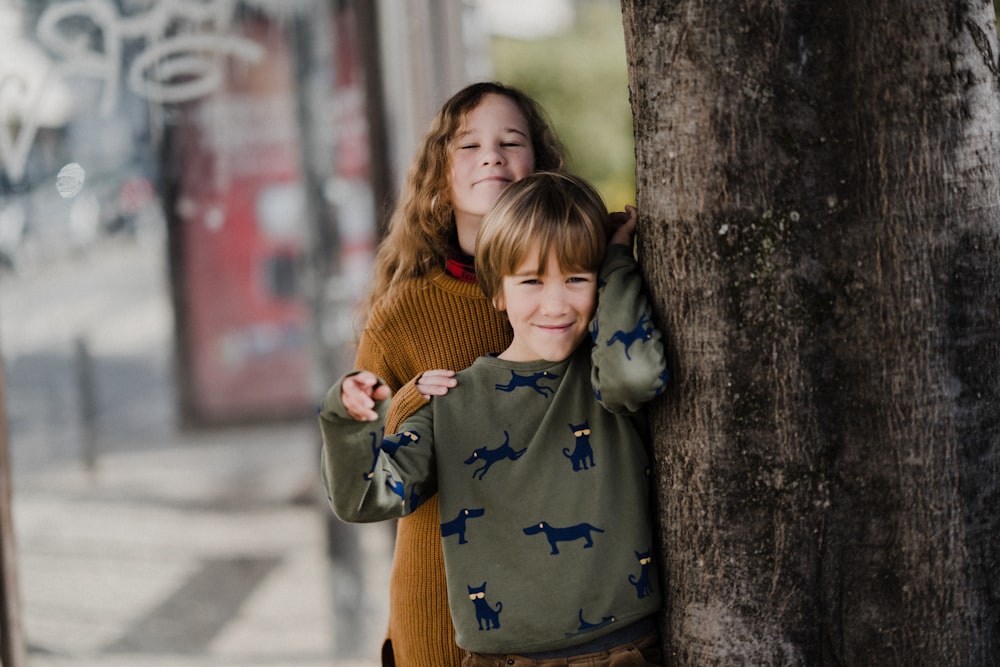 duas crianças pequenas se abraçando em uma calçada