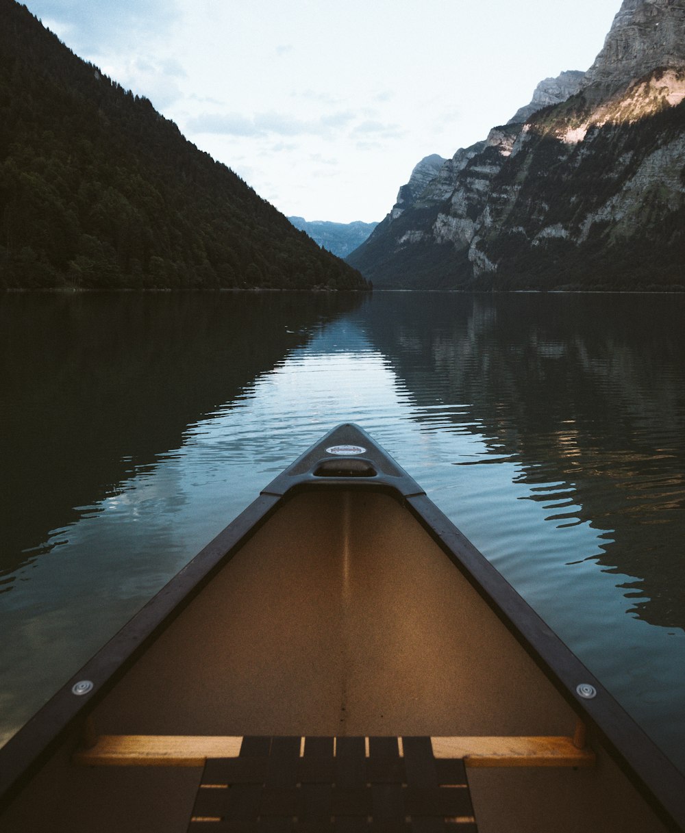 canoe on body of water with mountain background