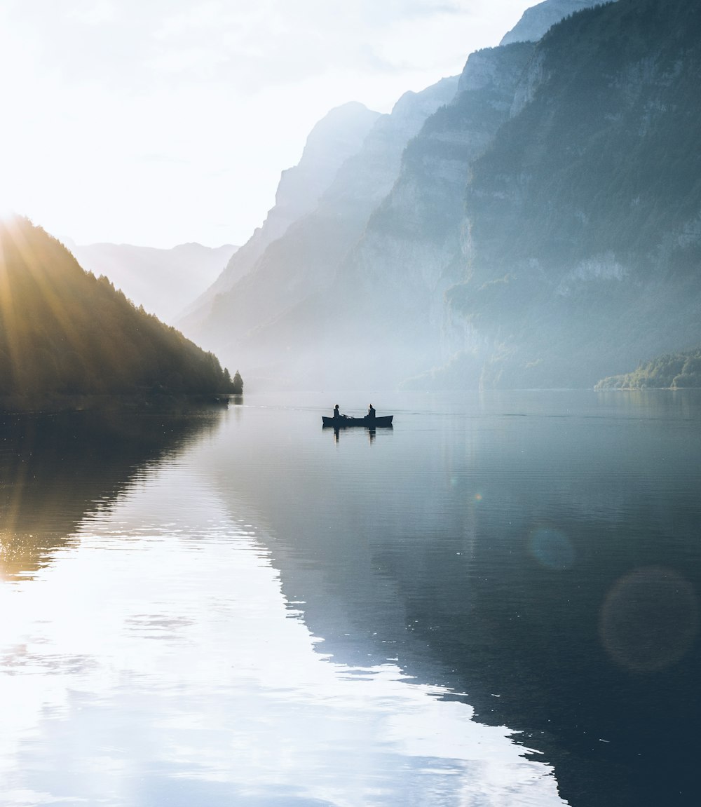 boat on body of water near rock mountains