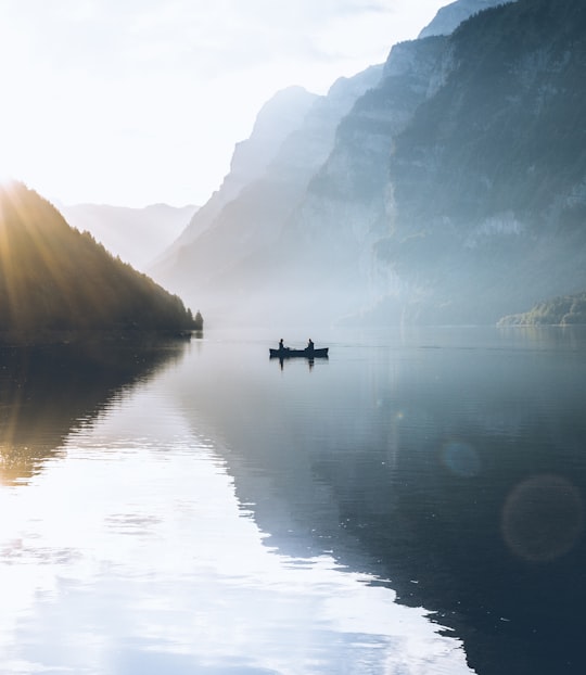 boat on body of water near rock mountains in Klöntalersee Switzerland