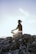 person sitting on rock formation during daytime