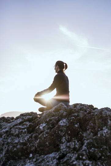 A serene person meditating outdoors during sunrise, symbolizing spiritual awakening.