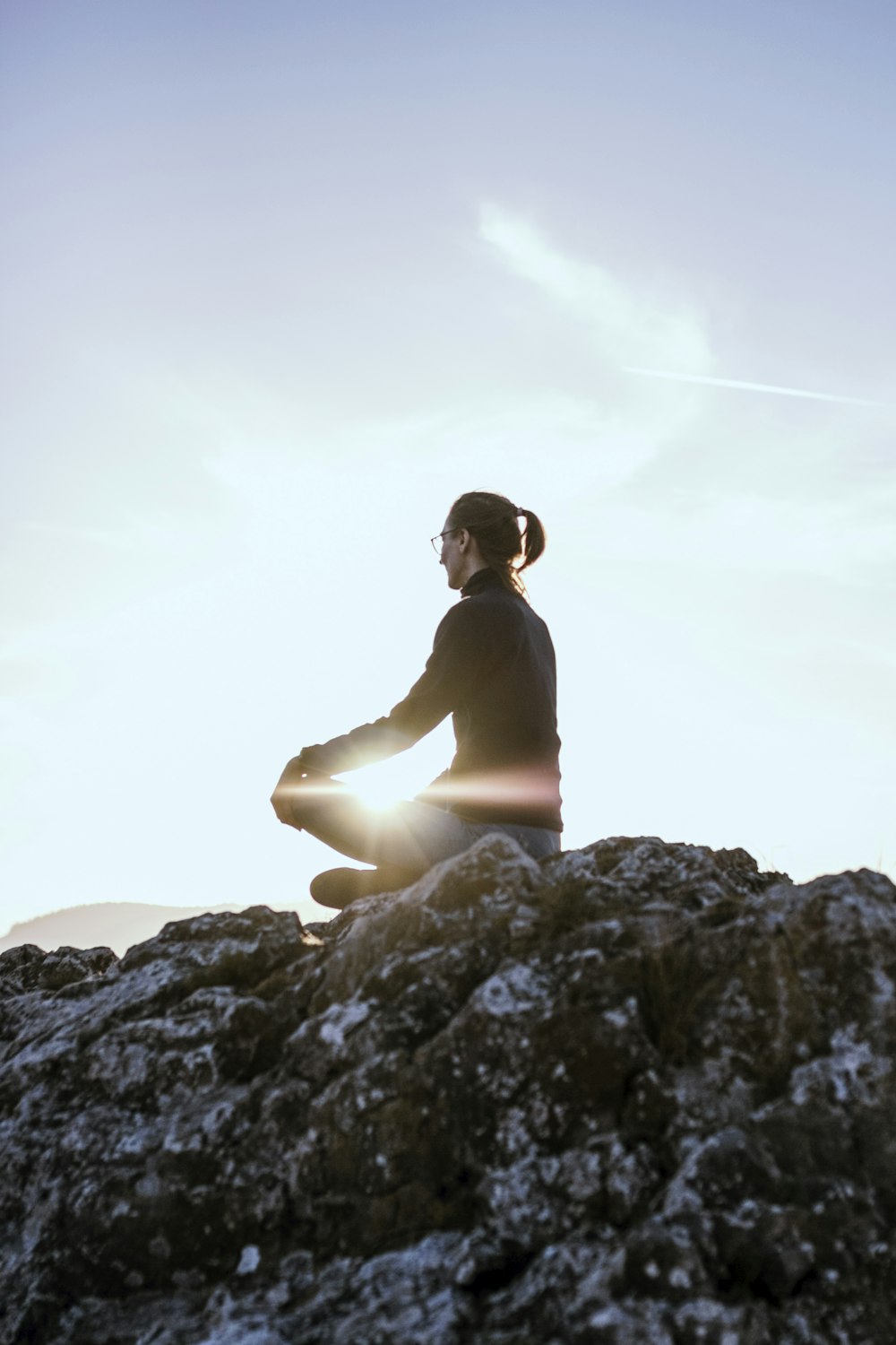 person sitting on rock formation during daytime