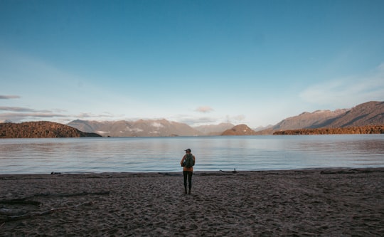 man stands in beach in Kepler Track New Zealand