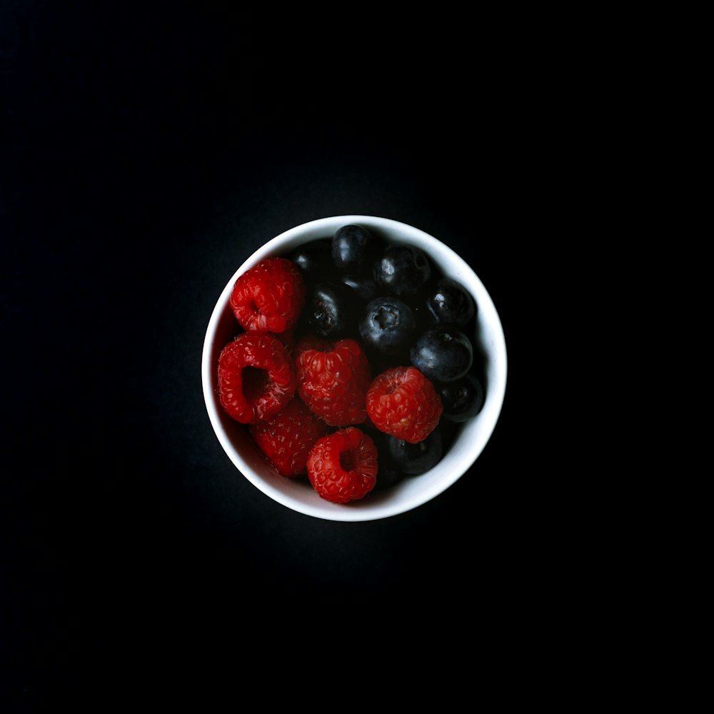 Myrtille et framboise sur bol en céramique blanche