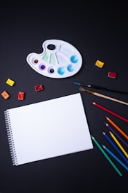 sketch pad with color pencil and paint brush