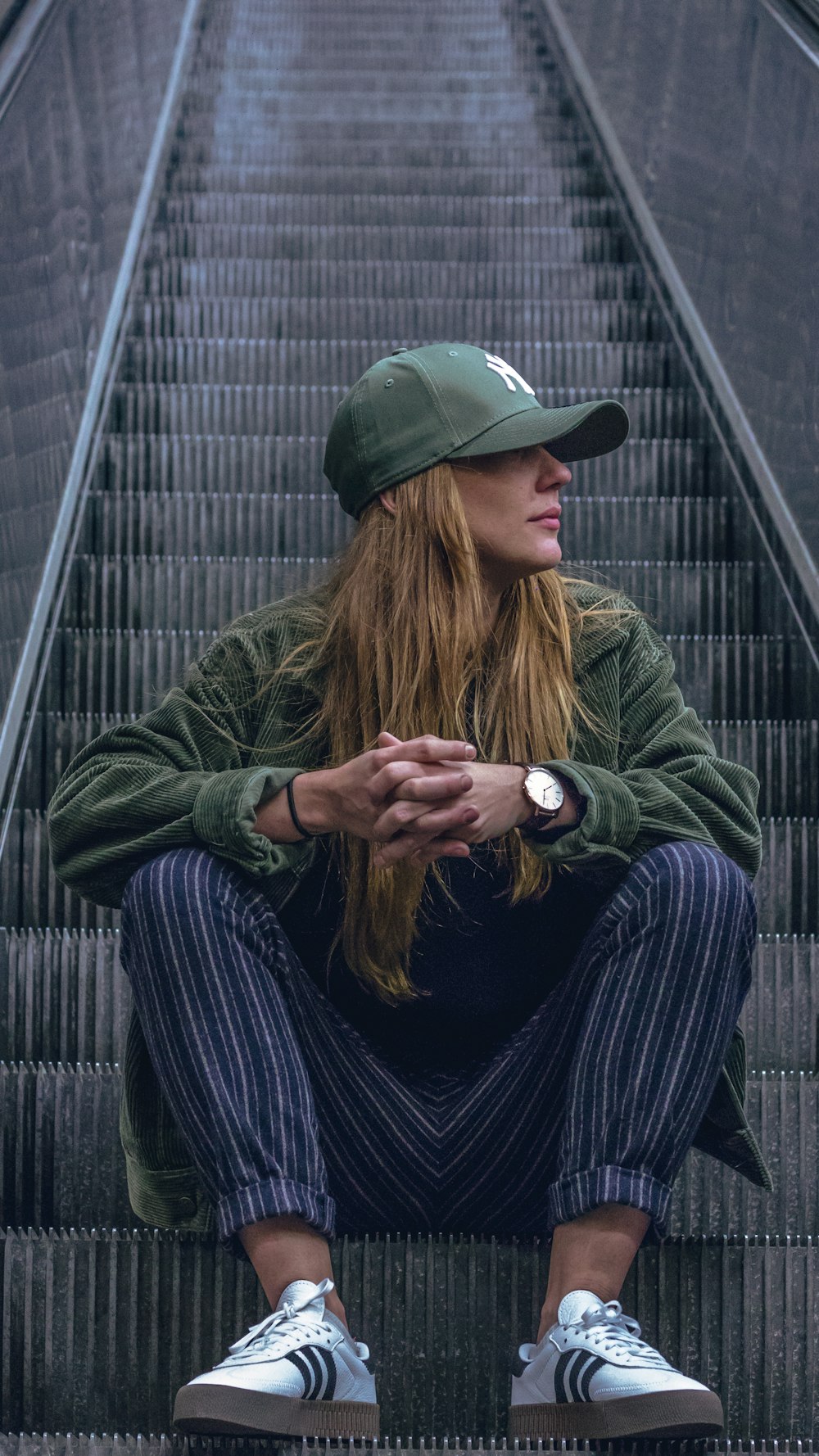 woman sitting on escalator