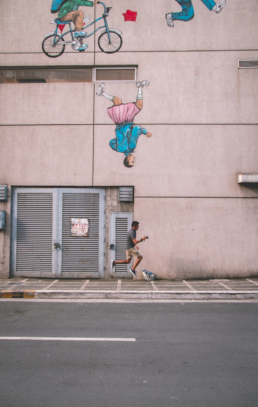 man jumping beside building during daytime