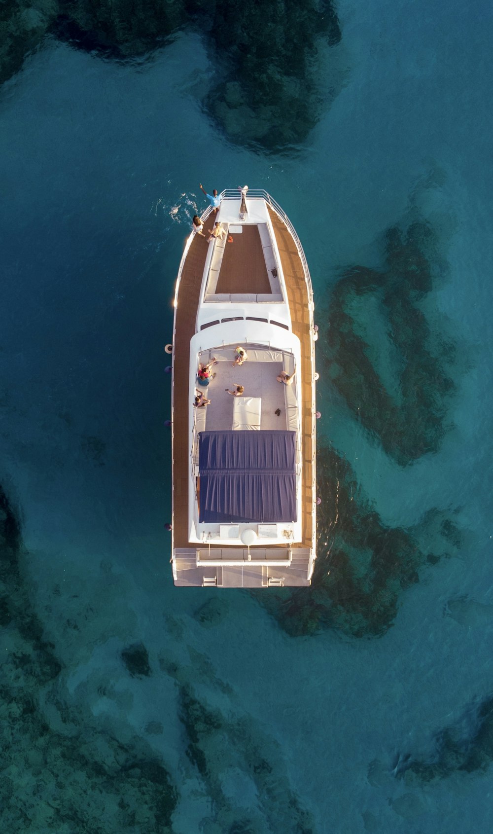 Photographie aérienne d’un bateau blanc et brun sur l’eau