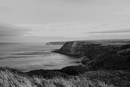 grayscale photography of cliff in Port Mulgrave United Kingdom