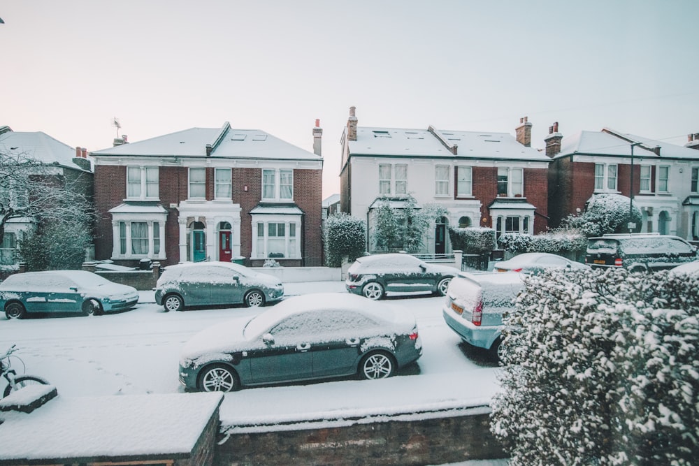 vehicles parked near houses covered in snow