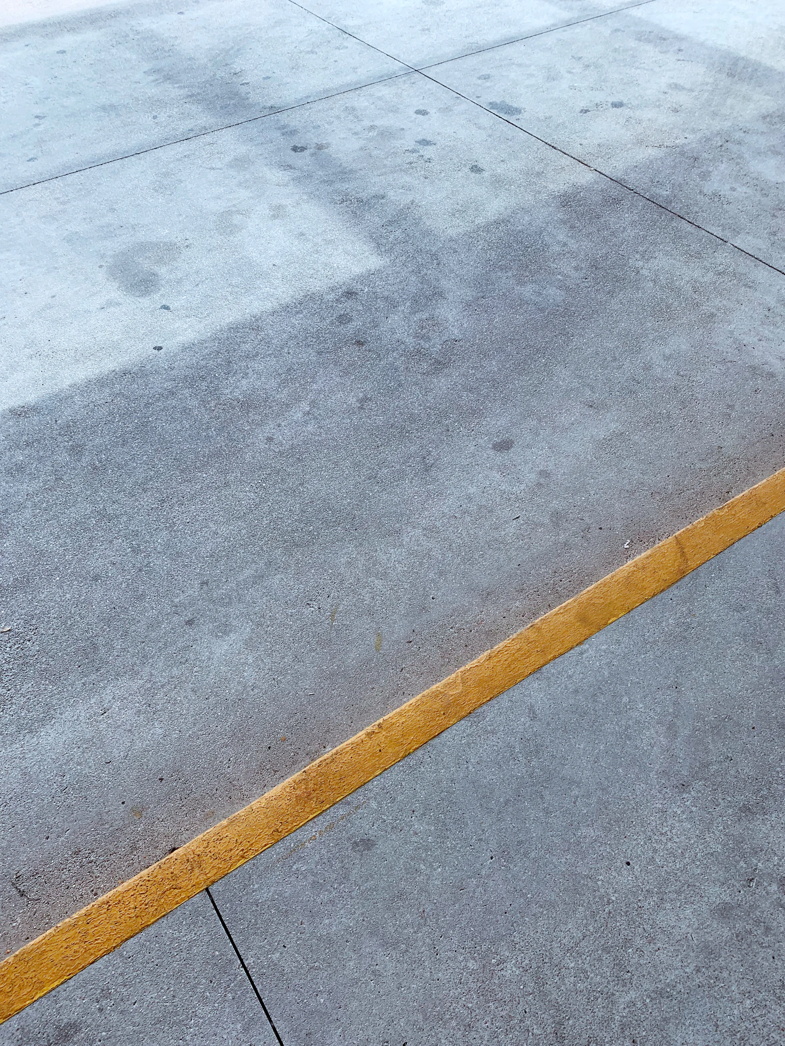 oil stained concrete garage floor in Toronto with dark motor oil marks on slab
