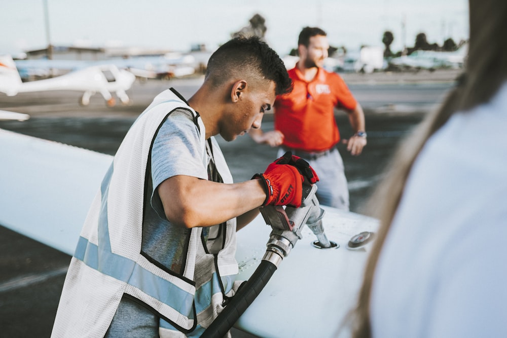 man fueling plane near man