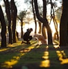 man in front of brown dog in woods