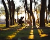 man in front of brown dog in woods