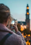 woman taking photo of a building during daytime