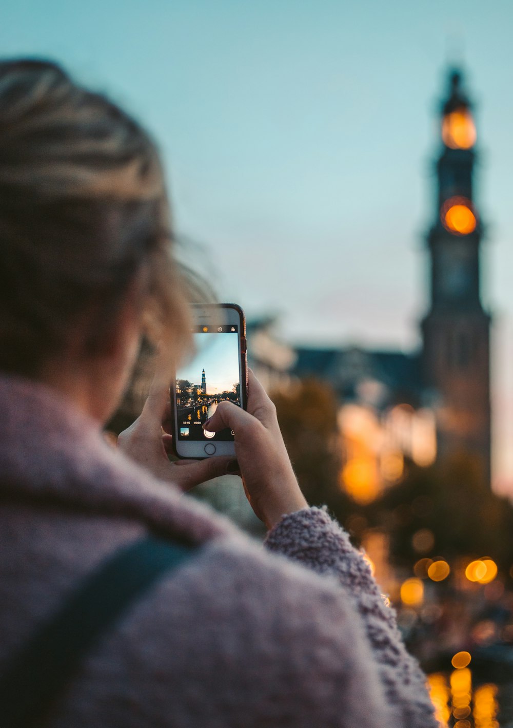 femme prenant une photo d’un bâtiment pendant la journée