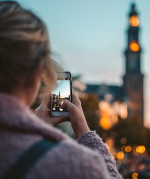 woman taking photo of a building during daytime