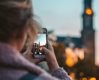 woman taking photo of a building during daytime