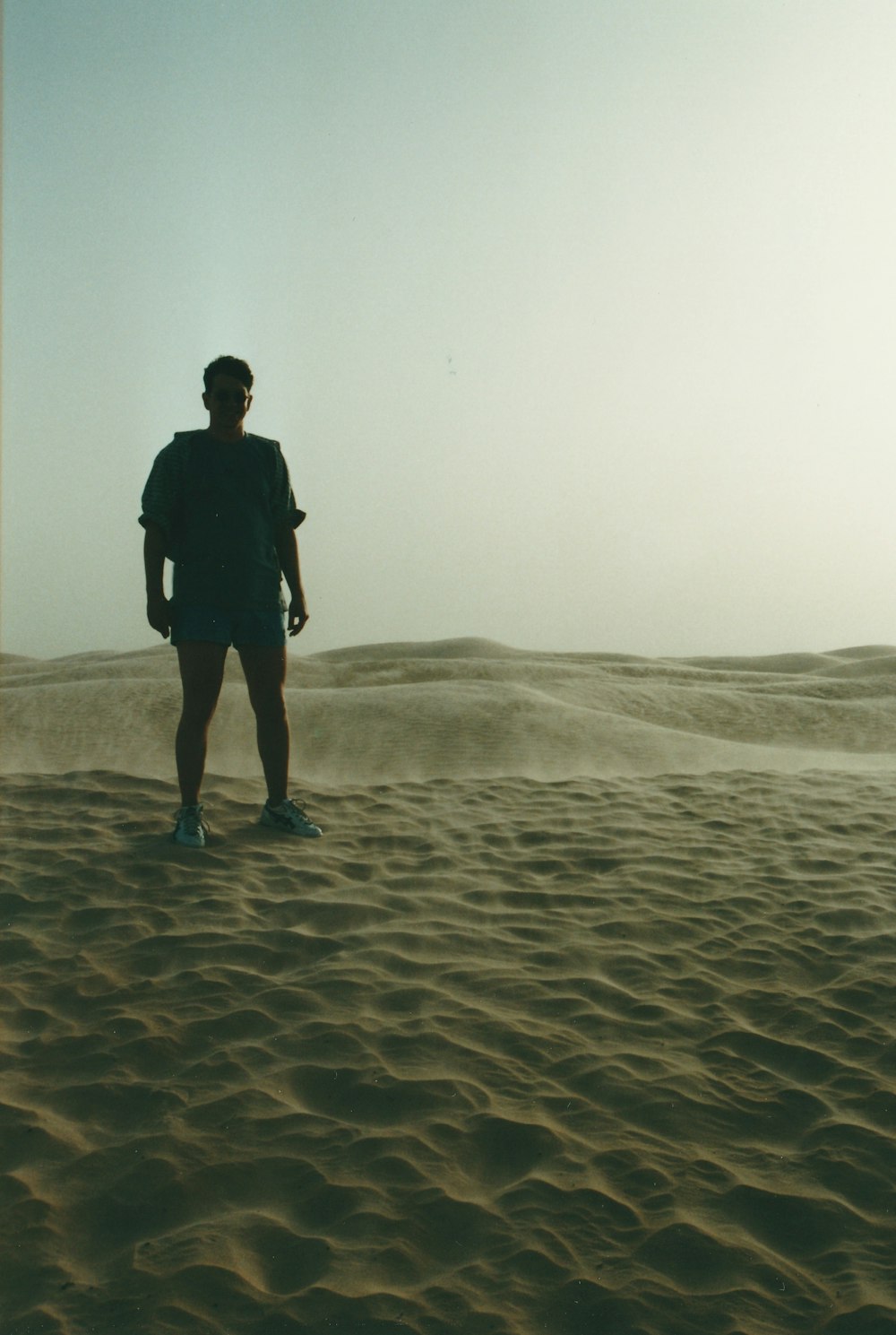 Silueta de hombre de pie sobre la arena