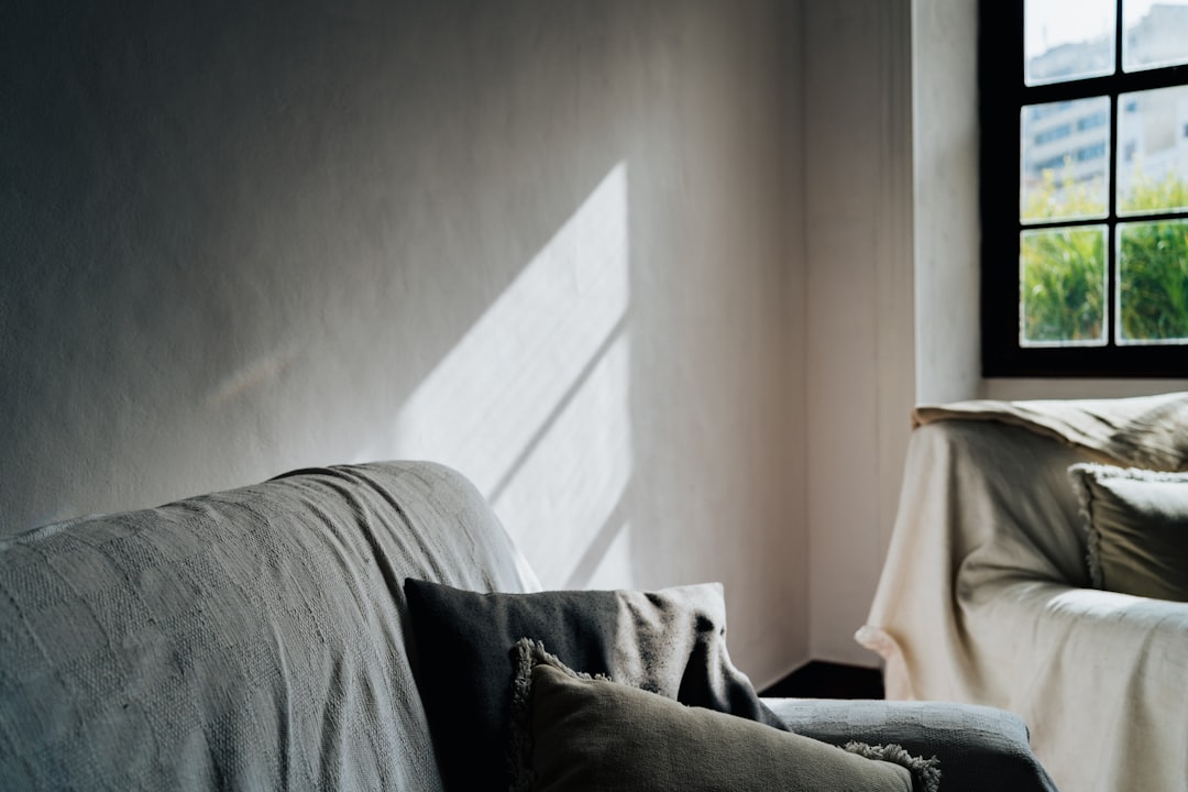 a couch sitting in a living room next to a window,