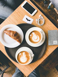 A cozy morning breakfast basket next to a smartphone displaying payment options.